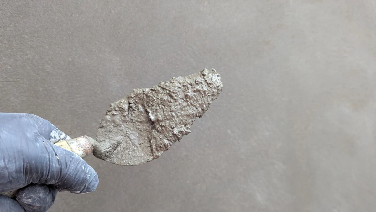 Stucwerk wordt met een spaan op een muur aangebracht